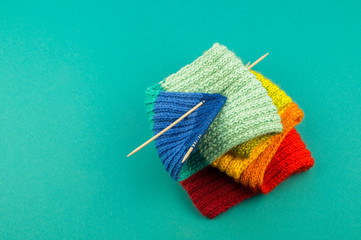 Knitting a rainbow scarf and hat Blue background