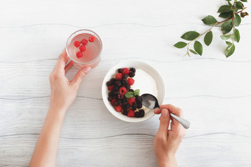 Delicious  breakfast with berries and yogurt on the white wooden table. Concept healthy food, diet. Top view.