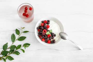 Delicious  breakfast with berries and yogurt on the white wooden table. Concept healthy food, diet. Top view.