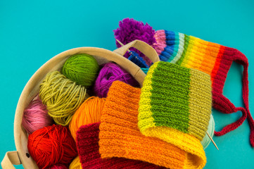 Knitting a rainbow scarf and hat Blue background