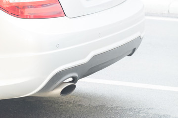 close up exhaust pipe of white car on the road for background.