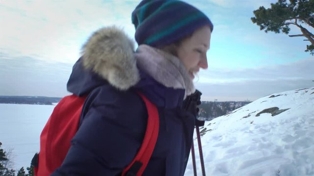 Group of young people hiking in mountains in winter. Backpackers walking on snow in Scandinavia, help each other, take pictures and enjoy nature