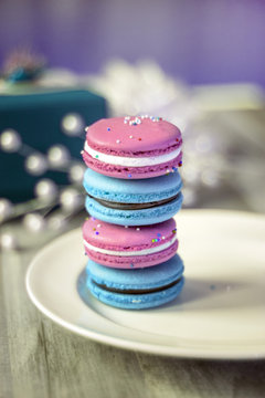 pink and blue french macaroon stacked on plates for birthday, baby shower or gender reveal party