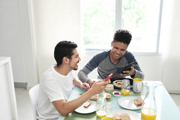 Fototapeta na wymiar Gay Couple Eating Breakfast At Home In the Morning