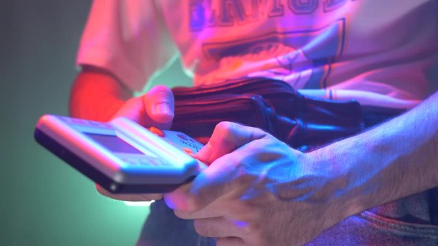 80's 90's gamer Playing with a retro gaming console in his hands.