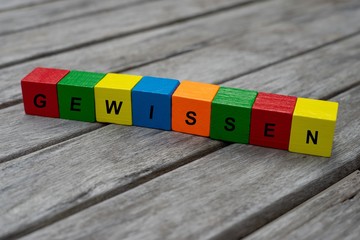 Farbige Holzwürfel mit Buchstaben auf dem das Wort Gewissen abgebildet ist, Abstrakte Illustration