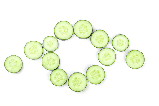 Cucumber slices in circle on white background with copyspace