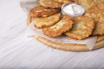 Tasty golden potato pancakes with sour cream. Copyspace
