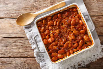Baked spicy beans prebranac close-up in a baking dish. Horizontal top view from above
