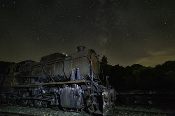 Old locomotive with  and milky way above it