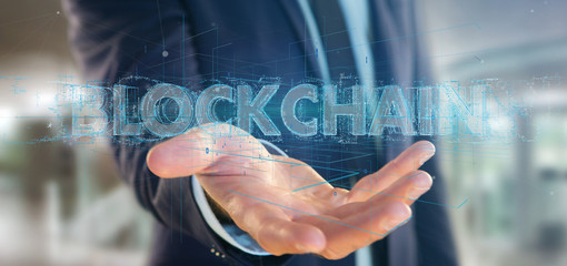 Businessman holding a Blockchain title isolated on a background
