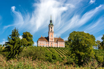 Beautiful landscape with vines and trees overlooking the pilgrimage church in Birnau on Lake Constance in front of a spectacular sky and clouds