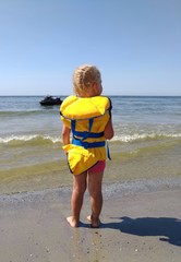 Fototapeta na wymiar Little girl in a yellow lifejacket