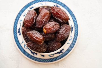 Fresh Medjool Dates in a bowl. Ramadan kareem. White background. Turkish style. Top view. Copy space.