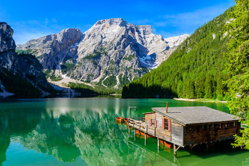 Fototapeta premium Lake Braies (also known as Pragser Wildsee or Lago di Braies) in Dolomites Mountains, Sudtirol, Italy. Romantic place with typical wooden boats on the alpine lake. Hiking travel and adventure. 