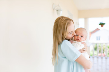 Mother holding a baby in her arms, family portrait.