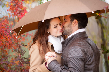 Couple of lovers kissing in the rain.