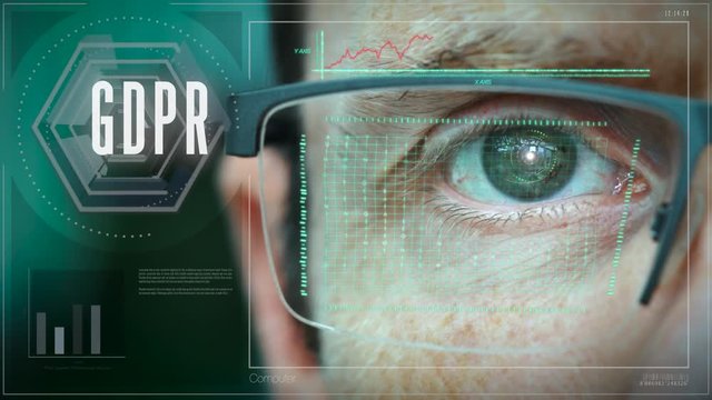 A close up of a businessman eye controlling a futuristic computer system with an GDPR concept.