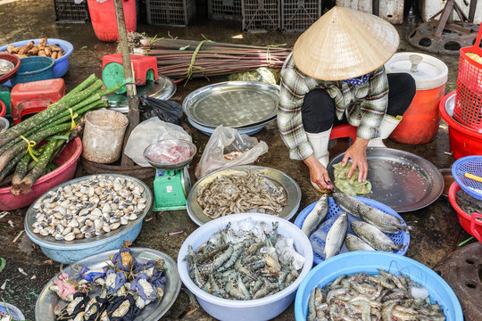 Woman selling fresh seafood at a market in Vietnam