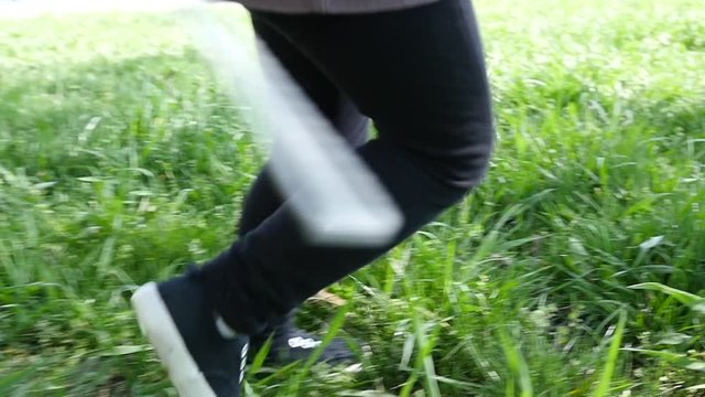 Kid child legs running on a park grass having fun slow motion low camera