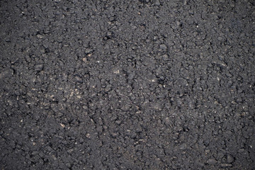 A dark grey asphalt pavement texture. Сlose-up of the repair of the road.