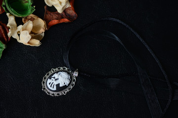 Halloween necklace with skeleton cameo pendant on a dark background close up