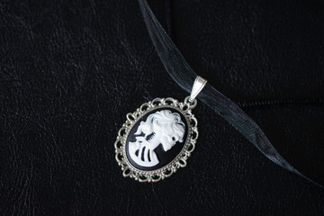 Halloween necklace with skeleton cameo pendant on a dark background close up - obrazy, fototapety, plakaty