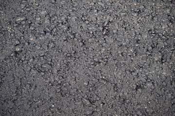 A dark grey asphalt pavement texture. Сlose-up of the repair of the road.