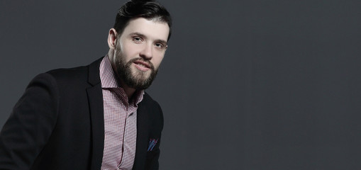 portrait of a stylish business man sitting on the back of a chair.isolated on grey background