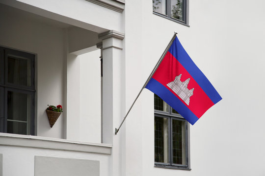 Cambodia flag. Cambodian flag hanging on a pole in front of the house. National flag of waving on a home displaying on a pole on a front door of a building. Flag raised at a full staff.