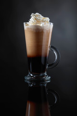 Coffee drink or cocktail with cream on a black background.