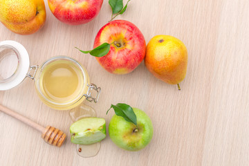 Jewish holiday Rosh Hashanah background with honey and apples on wooden table.
