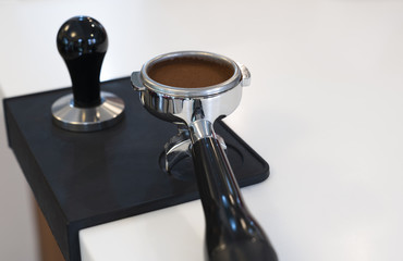 Tamped and compacted coffee grounds in a portafilter
