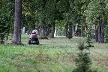 The man is mowing the grass on a tractor to mow the grass 