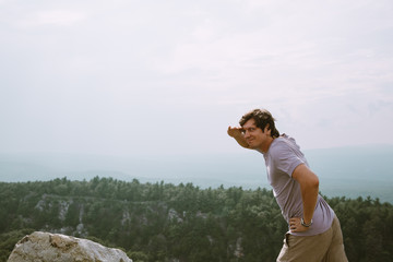 Fototapeta premium young man standing on the edge of mountains