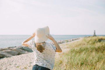 Young woman with straw hat near the seaside