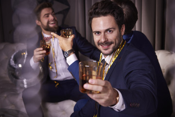 Group of businessmen with whiskey enjoying at night club