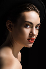 beautiful girl posing in elegant felt hat, isolated on black