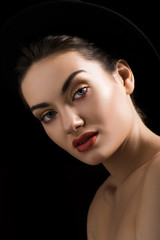 beautiful elegant girl posing in felt hat, isolated on black