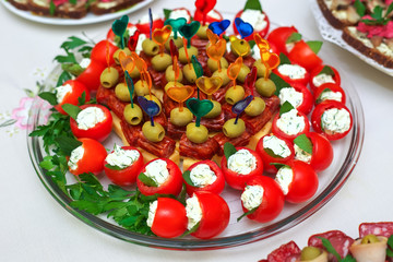 Canape on skewers with cheese, sausage and olives, tomato and on a buffet for a party or wedding, catering