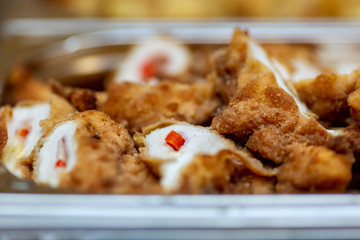 Close up photo of buffet tray with stuffed schnitzels sliced in half, decorated little piece of red pepper.