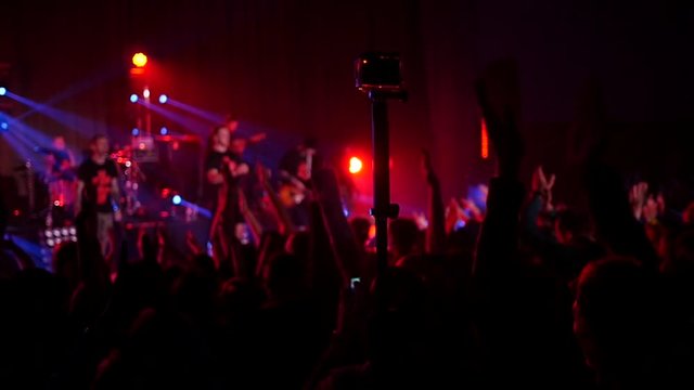 Crowd fan spectators silhouettes raise clap hands at concert light lumiere