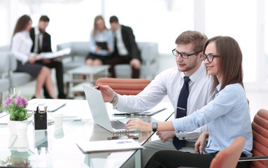 Young business man working together with her colleague on laptop in office.