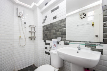 Obraz na płótnie Canvas Close-up small basin and equipment in small bathroom, on white ceramic wall 