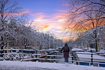 Amsterdam covered with snow  in winter in the Netherlands at sunset