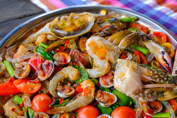 Som Tam Seafood (Spicy Papaya Salad) with salted crab, on wooden table ( Thai food)