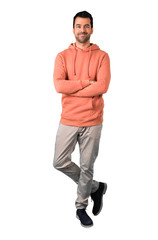 Fototapeta premium Full body of Man in a pink sweatshirt keeping the arms crossed in frontal position. Confident expression on isolated white background. Ideal for use in architectural designs