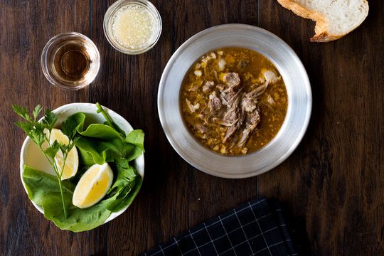 Turkish Soup Beyran with Lamb Meat, Rice, Chopped Garlic and Vinegar Sauce Served with Salad.