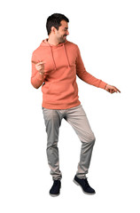 Naklejka premium Full body of Man in a pink sweatshirt enjoy dancing while listening to music at a party on isolated white background. Ideal for use in architectural designs
