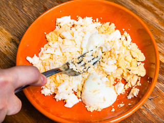 crushing the boiled eggs for stuffing by fork